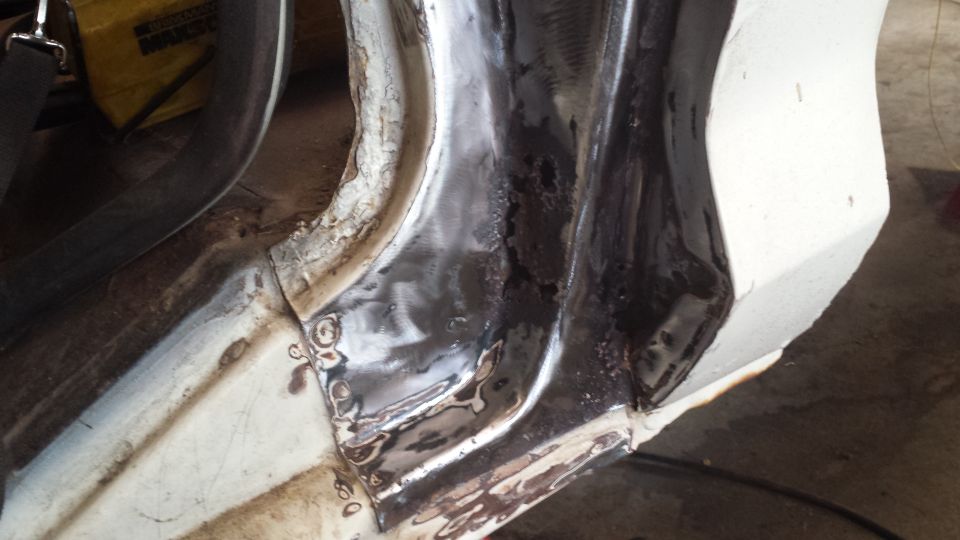 White vehicle body panel with fresh welds and dark primer