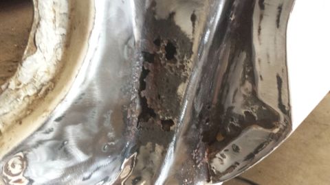 1978 Ford Bronco - This image shows a close-up of a heavily rusted metal panel, likely a part of a vehicle's body, with significant corrosion and holes.