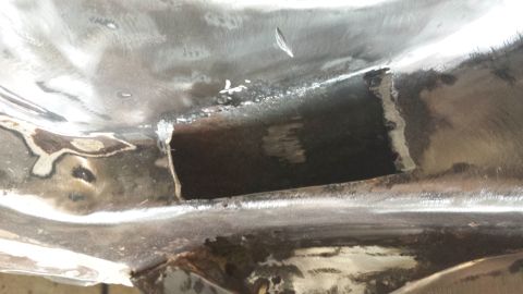 1978 Ford Bronco - Close-up of a vehicle's underbody, showing metalwork and a cut-out section.