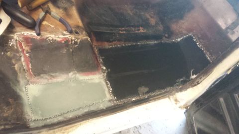 1978 Ford Bronco - This image shows extensive rust repair on a vehicle's floor pan, with a section cut out and new metal welded in place.