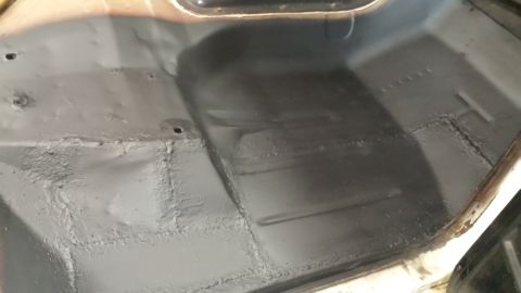1978 Ford Bronco - The interior floor of a vehicle, showing the undercoating and some signs of wear.
