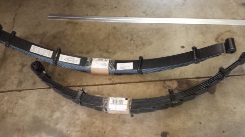1978 Ford Bronco - Two leaf springs are laid out on a concrete surface, with labels visible on both.