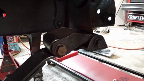 1978 Ford Bronco - Close-up of a vehicle's leaf spring and shackle assembly, painted black.