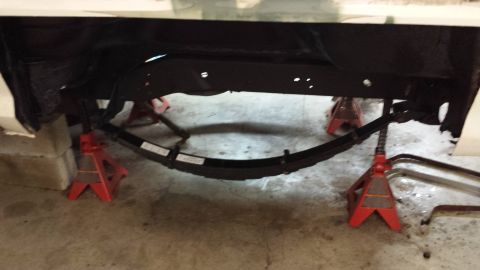 1978 Ford Bronco - Undercarriage view of a vehicle frame and suspension components on jack stands.