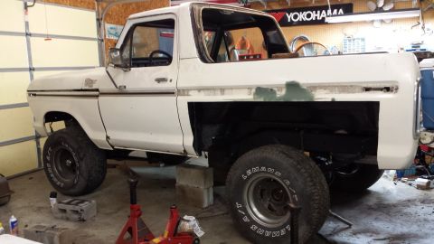 1978 Ford Bronco - This 1978 Ford Bronco is in a garage, supported by jack stands, with its rear quarter panel removed for work.