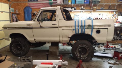1978 Ford Bronco - A white 1978 Ford Bronco is seen in a garage, supported by blocks and jack stands.