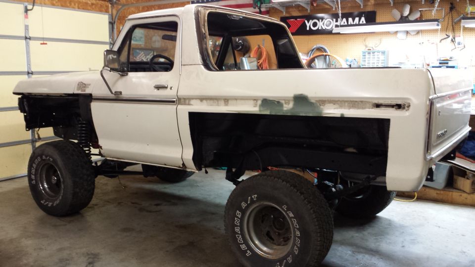 White 1978 Ford Bronco with missing front fenders and visible bodywork