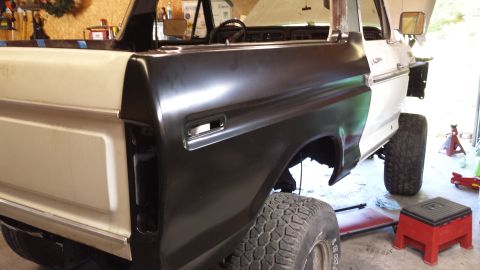 1978 Ford Bronco - The rear quarter panel of a Ford Bronco is being prepped for paint in a workshop setting.