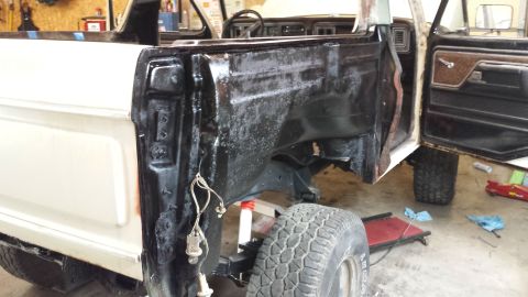 1978 Ford Bronco - The interior and rear quarter panel of a white 1978 Ford Bronco are visible, showing some bodywork in progress.