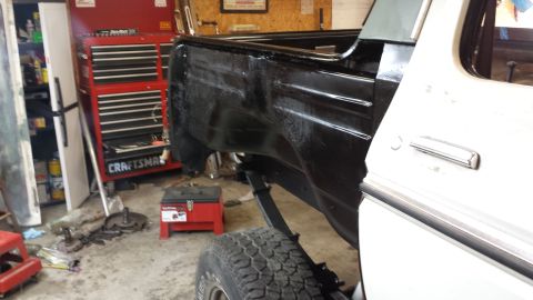 1978 Ford Bronco - Vehicle body in a garage setting, with a toolbox and parts visible. Restoration work is evident.