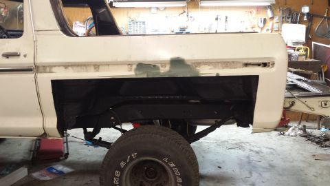 1978 Ford Bronco - The rear quarter panel of a 1978 Ford Bronco is shown with primer applied, indicating bodywork in progress.
