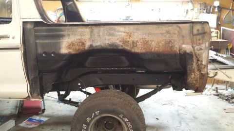 1978 Ford Bronco - This 1978 Ford Bronco shows significant rust on its rear quarter panel and visible suspension parts.