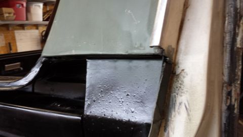 1978 Ford Bronco - Close-up view of the interior corner of a vehicle, showing black trim and a painted panel.