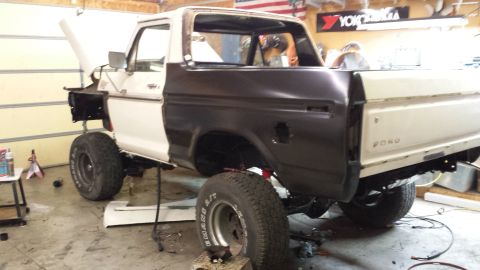 1978 Ford Bronco - A 1978 Ford Bronco is shown in a garage with its rear quarter panel replaced and the hood open.