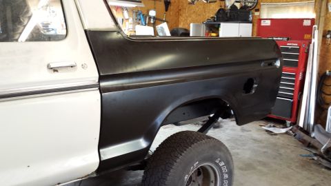 1978 Ford Bronco - The rear quarter panel of a Ford Bronco is shown in black primer, ready for further work.