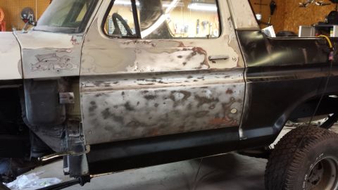 1978 Ford Bronco - This Ford Bronco is undergoing body repairs, with sections of primer and exposed metal visible on its side.