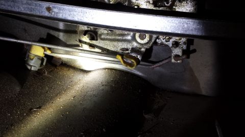 1978 Ford Bronco - This is a close-up view of a vehicle's door latch assembly, showing mechanical components and cables.