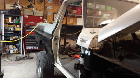 1978 Ford Bronco - Interior view of a truck undergoing restoration, with the door open and hood up.