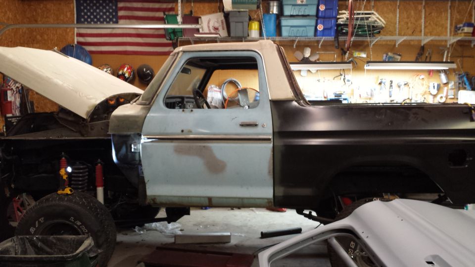 1978 Ford Bronco with hood open and body panels removed, in a garage