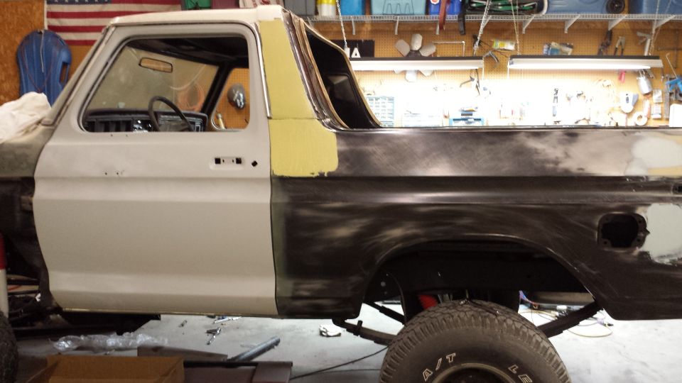 Side view of a 1978 Ford Bronco with primer and bodywork visible