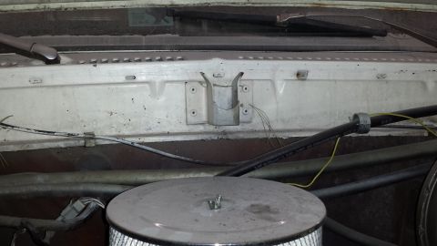 1978 Ford Bronco - The engine bay of a vehicle shows an air cleaner, hoses, and windshield wipers.