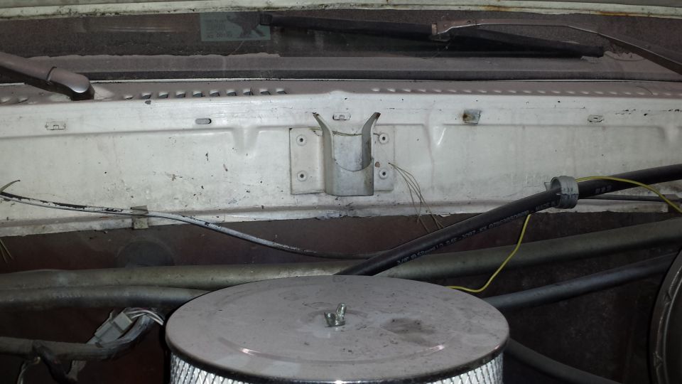 Engine bay with air cleaner, hoses, and windshield wipers visible