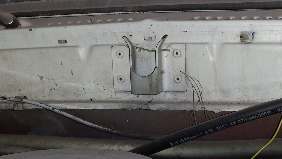 Engine bay bracket and hose with visible text 'SUPERMOTORS'