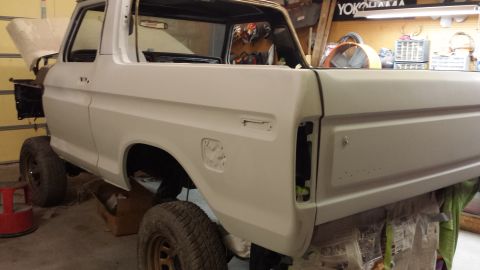 1978 Ford Bronco - This 1978 Ford Bronco is in a garage, likely undergoing restoration, shown from a three-quarter front perspective.