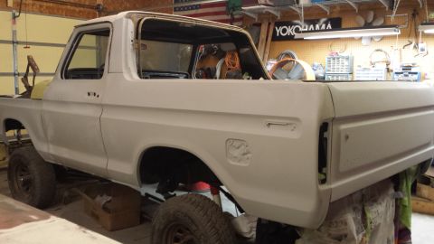 1978 Ford Bronco - Side view of a 1978 Ford Bronco body, prepped for paint in a workshop.