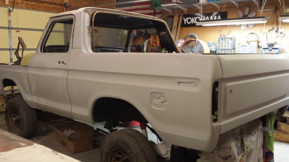 1978 Ford Bronco body in primer, undergoing restoration in a garage
