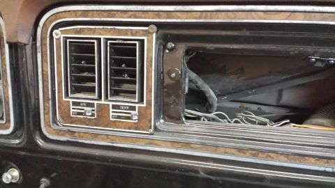 1978 Ford Bronco - Interior view of the dashboard air vents and controls on a 1978 Ford Bronco, wood grain trim and visible wiring.