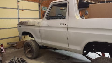1978 Ford Bronco - This white truck, likely from the 1970s, is undergoing restoration in a garage.