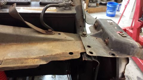 1978 Ford Bronco - Close-up of a car battery and associated metal components, showing signs of rust and wear.