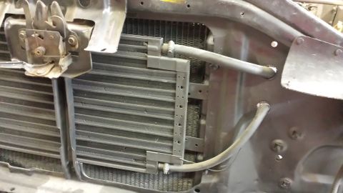 1978 Ford Bronco - Close-up view of the front end's radiator and condenser assembly, showing hoses and latch components.