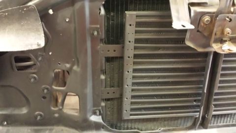 1978 Ford Bronco - Close-up view of a vehicle's radiator and its mounting hardware.