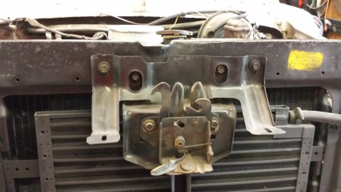 1978 Ford Bronco - Close-up of a vehicle's hood latch mechanism and radiator assembly.