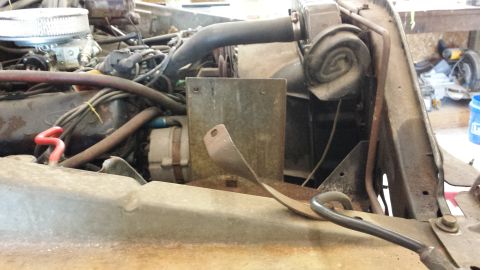 1978 Ford Bronco - Engine bay of a 1978 Ford Bronco, showing the carburetor, alternator, and radiator hoses.