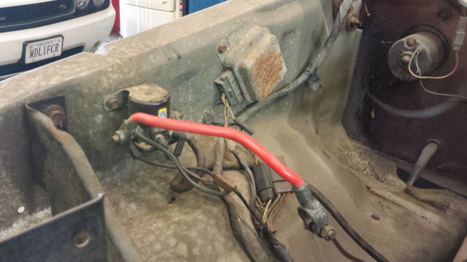 Engine bay wiring with red cable and electrical components