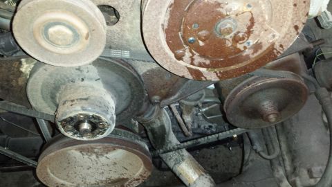1978 Ford Bronco - Close-up view of corroded engine pulleys and belts, with visible water stains.