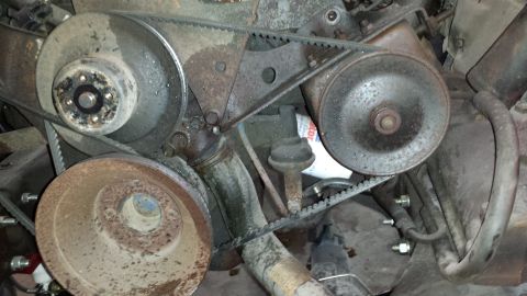 1978 Ford Bronco - Close-up view of an engine bay, showing multiple belts and pulleys, along with an oil filter.