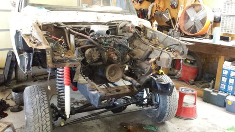 1978 Ford Bronco - Front end of a 1978 Ford Bronco undergoing repairs, with the engine removed and chassis exposed.