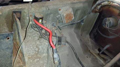 1978 Ford Bronco - Close-up view of the engine bay wiring harness, including a prominent red battery cable and fuse box.