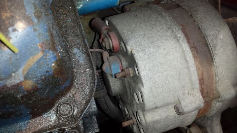 1978 Ford Bronco - This is a close-up view of an alternator and part of an engine block, showing some wear and tear.