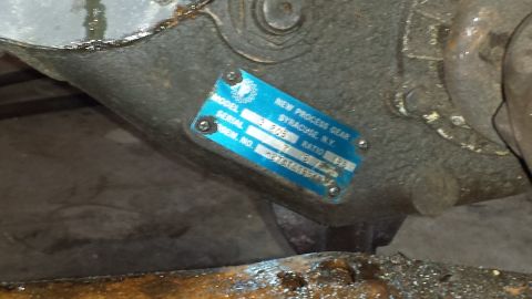 1978 Ford Bronco - Close-up of a New Process Gear tag on a transmission housing, showing model and serial numbers.