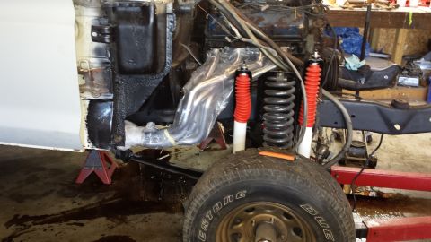 1978 Ford Bronco - The front suspension and engine bay of a 1978 Ford Bronco are visible, undergoing mechanical work.