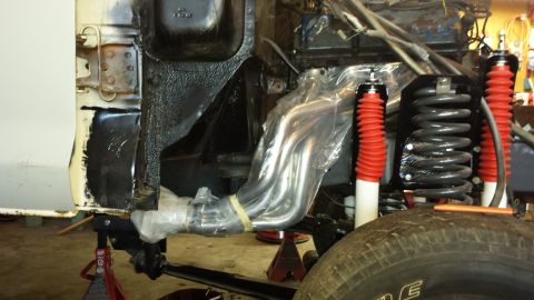 1978 Ford Bronco - The engine bay of a 1978 Ford Bronco shows new chrome exhaust headers and bright red shocks during a restoration.