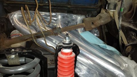 1978 Ford Bronco - Close-up view of automotive parts, including a steering column and suspension components, with some items wrapped in plastic.