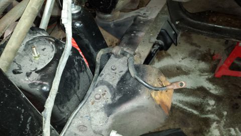 1978 Ford Bronco - Close-up view of vehicle suspension components, showing wiring and a red jack stand supporting the frame.