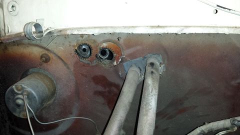 1978 Ford Bronco - Close-up of the firewall area on a 1978 Ford Bronco, showing the heater core tubes and grommets.