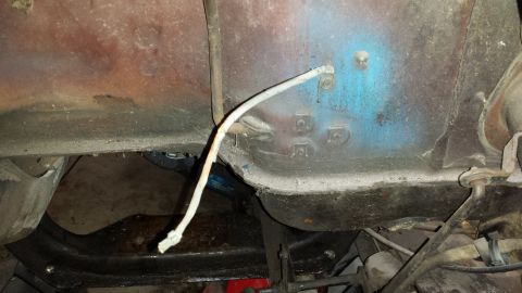 1978 Ford Bronco - Underside view of vehicle frame and suspension components, showing rust and some blue paint.